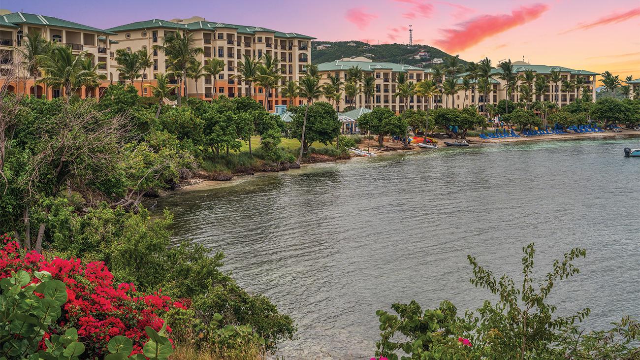 Exterior of The Ritz-Carlton Club Saint Thomas resort timeshare from the lagoon at sunset